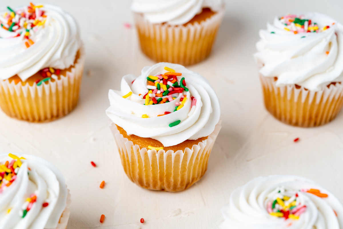 An Easy Recipe For Vanilla Cupcakes Topped With A Simple Vanilla Buttercream Frosting These C