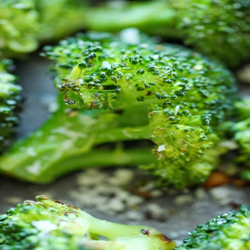 Broccoli Florets Are Sitting On A Plate With Parmesan Sprinkles