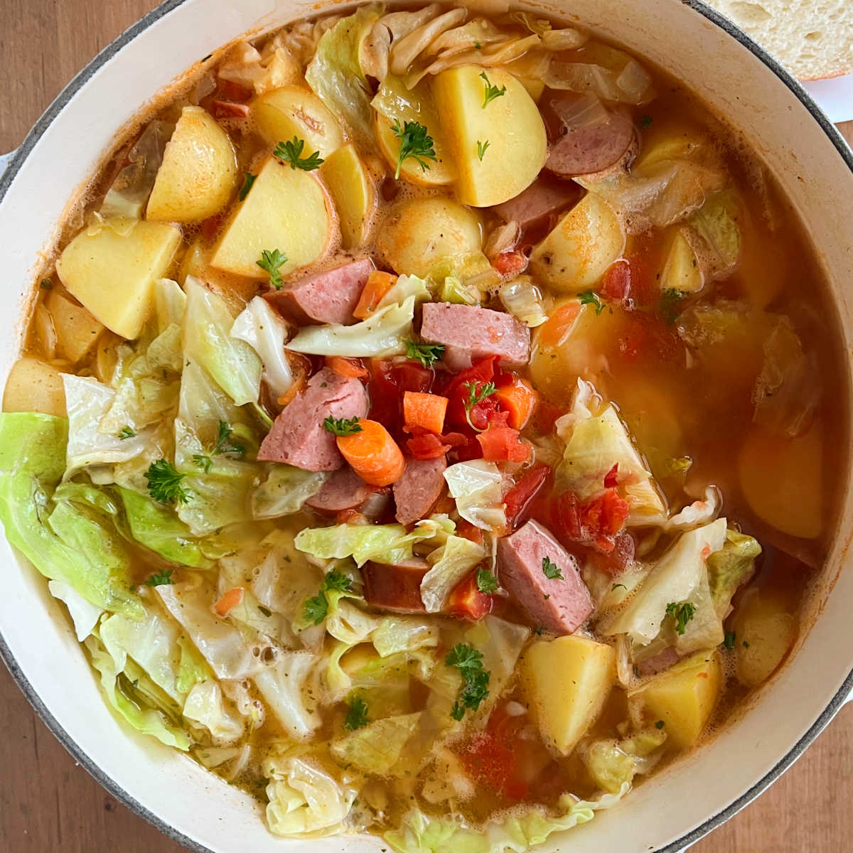 Cabbage Soup With Sausage In A White Bowl