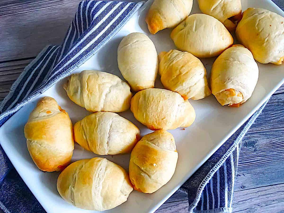 Mini Hot Dogs Wrapped In Crescent Rolls On Parchment Paper Hotappetizerideas Dog Recipes